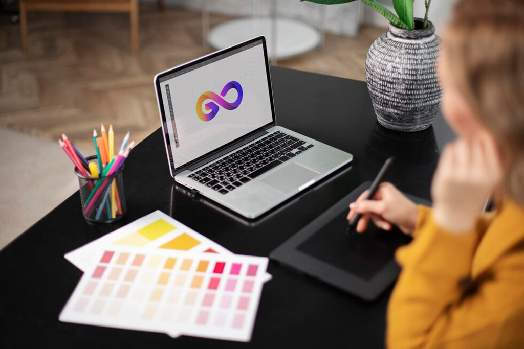 Logo design workspace with laptop and color swatches